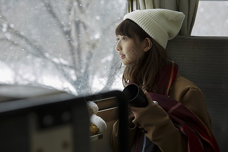 冬季女学生看向窗外的雪图片