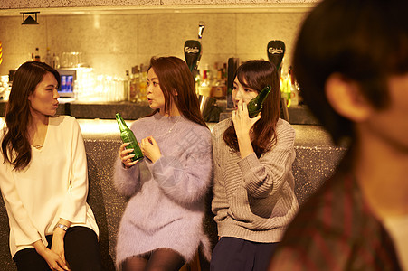 年轻女孩在俱乐部现场酒吧柜台喝酒图片