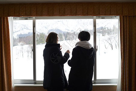 情侣在酒店看窗外雪景背景图片