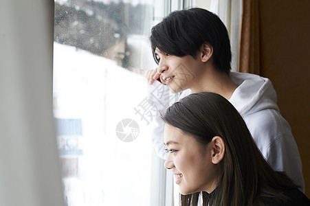 情侣在酒店看窗外雪景图片