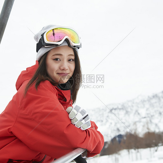 乘坐缆车到雪山顶的年轻女性图片