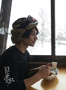 滑雪场餐厅享用午餐的男性图片