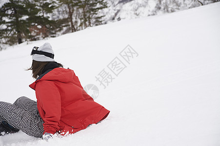 摔倒在滑雪场的女性背影图片