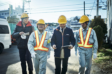 在建筑工地检查作业的蓝领工人图片