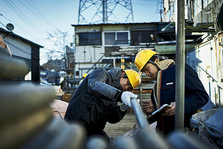 在建筑工地检查作业的蓝领工人图片