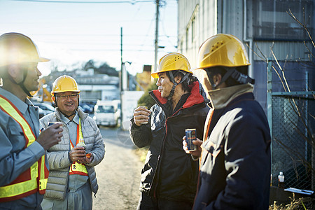 建筑工地工人男人们喝饮料休息图片