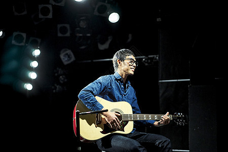 男人在舞台上演奏弹吉他图片