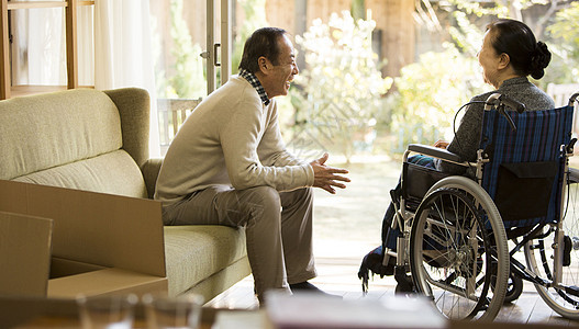 坐轮椅的妻子和他的丈夫在客厅聊天图片