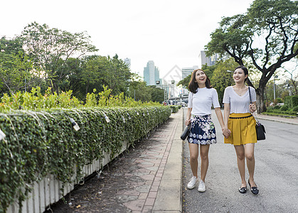 女人手牵手在路边散步图片