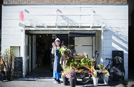 在花店门口的花店女老板图片