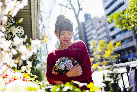  抱着一束花的女性图片