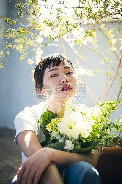  抱着花的女性图片