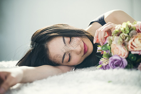 快乐的美人欣赏与玫瑰花束的女画象图片