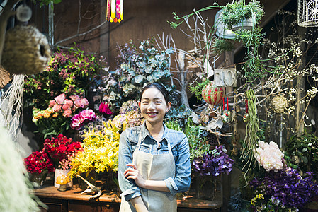 年轻店内室内盆栽工作在花店的妇女图片