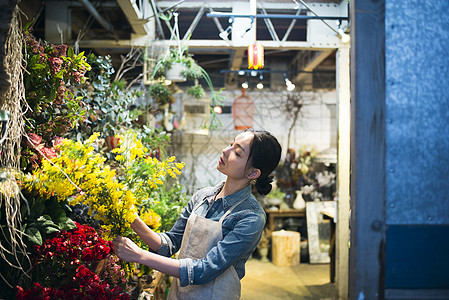 销售植物幸福工作在花店的妇女图片