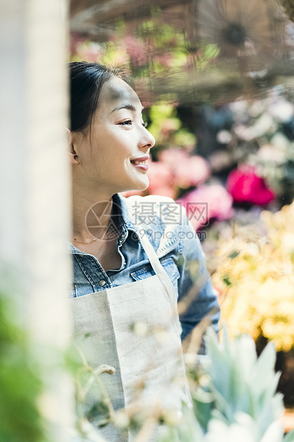 植物人销售围裙工作在花店的妇女图片