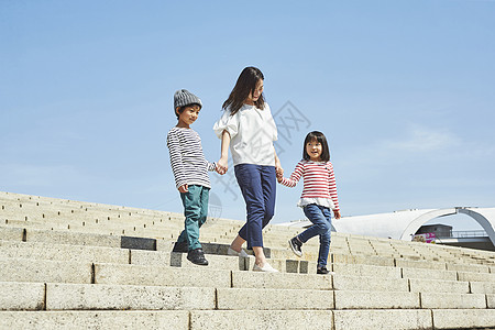 手牵手走在阶梯上的一家三口图片素材