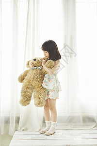 抱着泰迪熊布娃娃的女孩图片