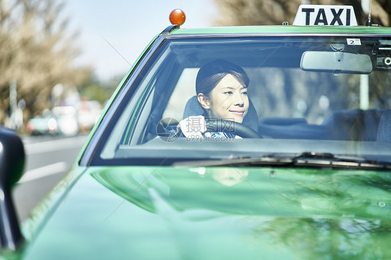 驾驶中的女性出租车司机图片