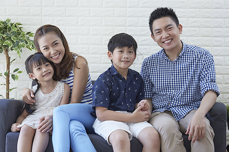 坐在西瓜中的男孩一家四口坐在客厅中微笑背景