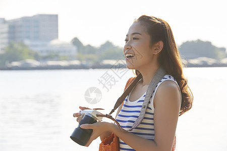 拿着相机微笑的年轻女性图片