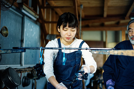 年轻女性拿去染料池里的布料图片