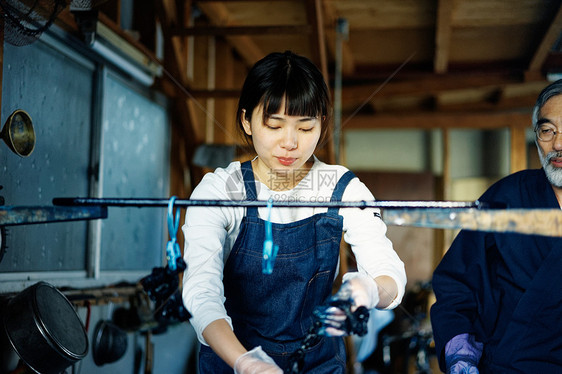 年轻女性拿去染料池里的布料图片