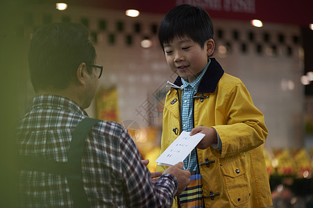 一个男孩和水果商交谈购物买菜图片