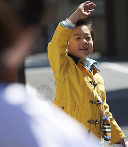 晴天街道挥手告别的小男孩背景
