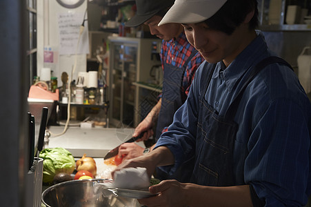 汉堡店厨师为制作汉堡备菜图片