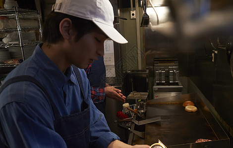 汉堡店厨房厨师在调味料理图片