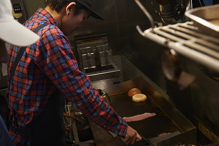 汉堡店厨房厨师在调味料理图片