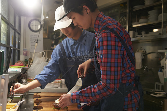 汉堡店厨师为制作汉堡备菜图片