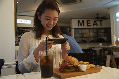 一个女人在汉堡店用餐图片