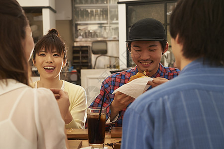 汉堡店享用午餐的青年男女图片