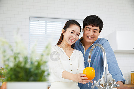 在厨房洗水果的夫妻二人图片