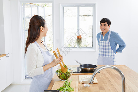年轻夫妻在厨房一起做饭图片