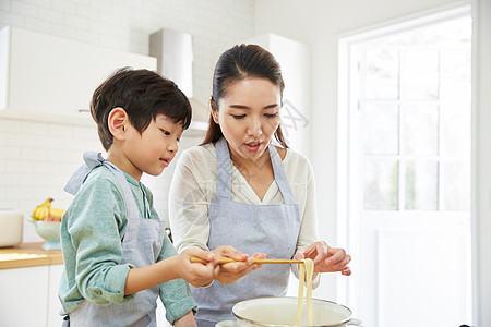 厨房里制作面条的母子图片