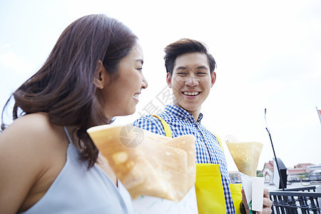 开心的拿着煎饼的年轻夫妇图片