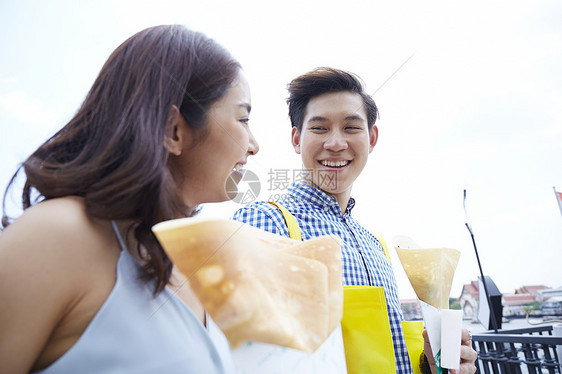 开心的拿着煎饼的年轻夫妇图片