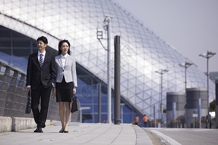 商务都市男女站在机场天桥上图片