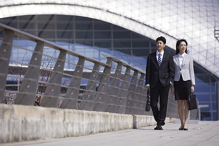 商务都市男女站在机场天桥上图片