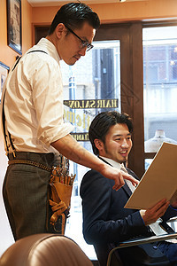 穿衬衫系领带的文艺理发师与顾客交流图片