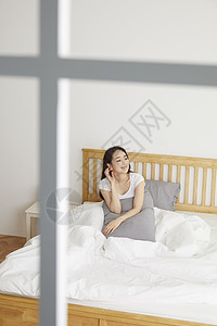 床上微笑的年轻女性图片