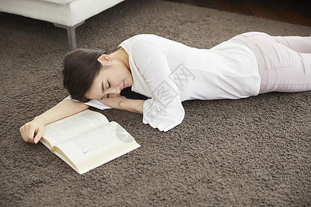 地毯读书趴在地毯上沉睡的年轻女子居家生活背景