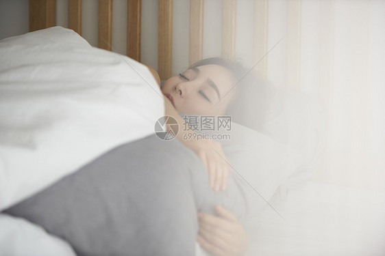 床上休息睡觉的年轻女性图片