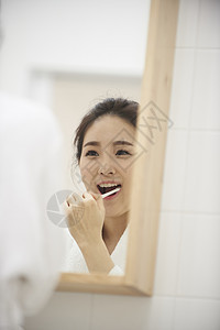 镜子前洗漱的年轻女性图片