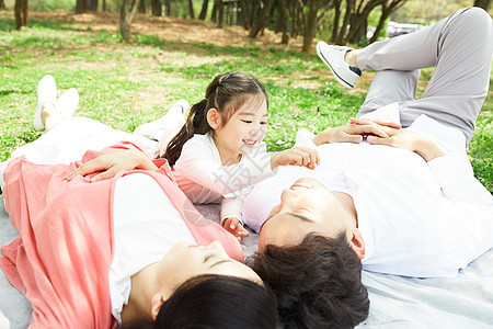 躺在野餐垫上休息的一家人图片