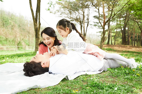 野餐垫上放松休息的一家人图片