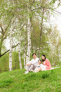 坐在草坪上郊游休息的一家人图片